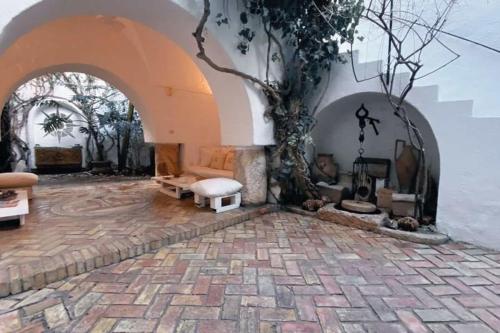 a room with an arch with a tree in it at Maison Les Cyprès in Hammamet
