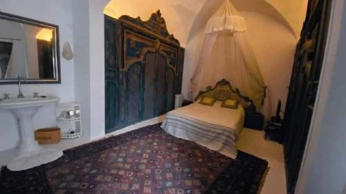 a bedroom with a bed and a sink and a mirror at Maison Les Cyprès in Hammamet
