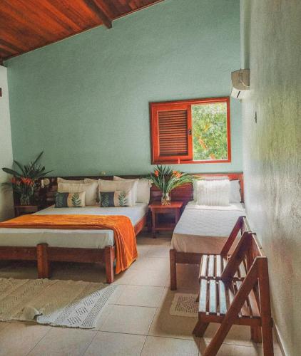 a bedroom with two beds and a window at Pousada Maliale in Ilha de Boipeba