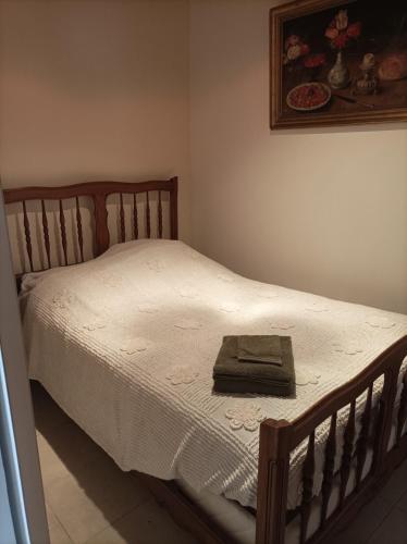 - un lit avec un cadre en bois et une serviette dans l'établissement Le mas de la Treille, à Asnières-en-Poitou