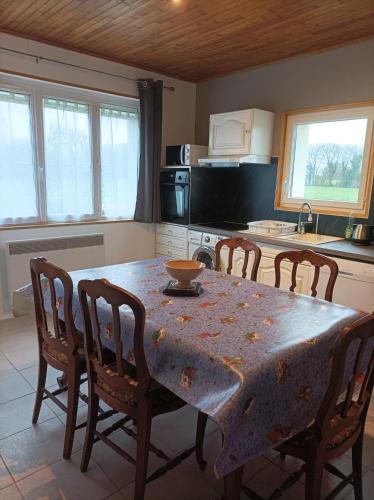 une cuisine avec une table et des chaises ainsi qu'une cuisine avec une table et des chaises dans l'établissement Le mas de la Treille, à Asnières-en-Poitou