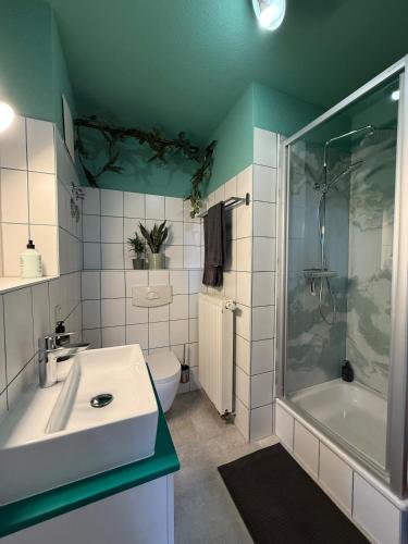 a bathroom with a sink and a shower and a toilet at Stadt Flair in Eisenach