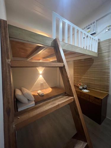 a wooden staircase with a bunk bed in a room at Balay na Bato in Legazpi