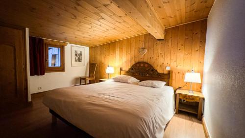 Cette chambre en bois comprend un grand lit. dans l'établissement Appartement Avec Sauna, à Chamonix-Mont-Blanc
