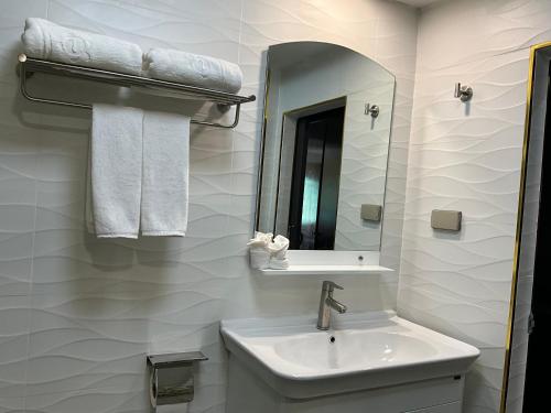 a white bathroom with a sink and a mirror at Pattaya Tower EVO 401 in Pattaya Central