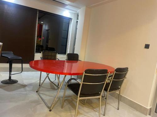 a red table with chairs around it in a room at BLUE ANGEL Guest House in Shillong