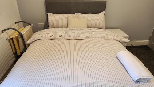 a large bed with a white and gray striped comforter at Manor House walsall 3 in Walsall