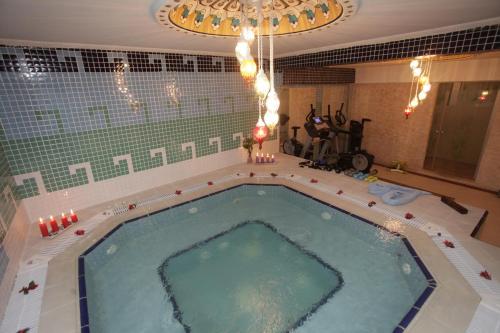 una grande piscina in un bagno con un lampadario di Marmaray Hotel a Istanbul