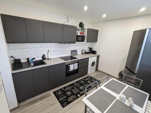a kitchen with black and white appliances and a table at Smart Apartment in Znojmo