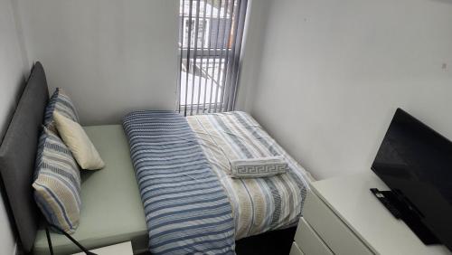 a bench in a room with a bed and a television at Manor hause walsall 4 in Walsall