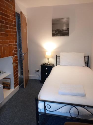 a bedroom with a bed and a brick wall at Number Three in Brighton & Hove