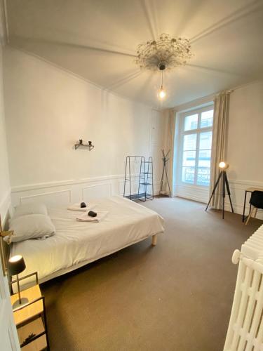 une chambre blanche avec un lit et une fenêtre dans l'établissement L'Appartement Privilège - 4 chambres - Coeur d'Angers, Spacieux et Élégant, à Angers