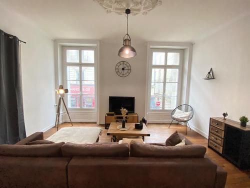 a living room with a couch and a table at L'Appartement Privilège - 4 chambres - Coeur d'Angers, Spacieux et Élégant in Angers