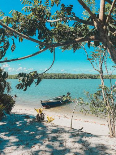 a boat sitting on a beach next to the water at Pousada Maliale in Ilha de Boipeba