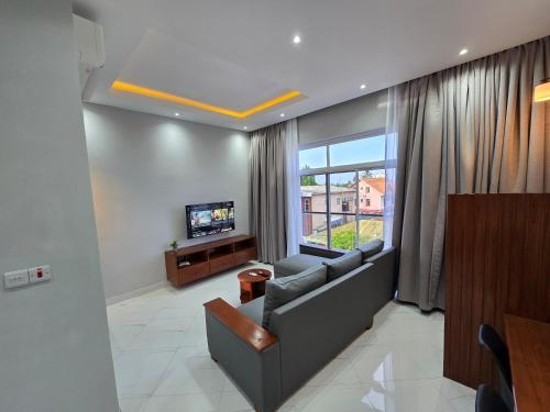 a living room with a couch and a tv at Jaxvilla Appartments in Dar es Salaam
