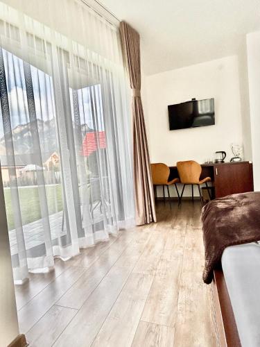 a living room with a large window and a television at Willa Asia in Sromowce Niżne