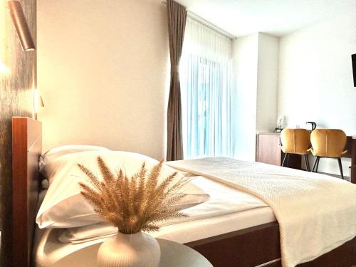 a bedroom with a bed with a vase on a table at Willa Asia in Sromowce Niżne