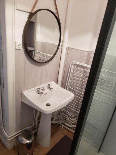 une salle de bain avec un lavabo et un miroir dans l'établissement Bel appartement, à Boulogne-sur-Mer