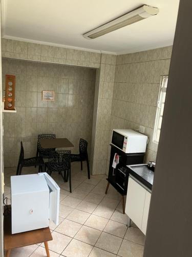 a small kitchen with a table and a microwave at Panamá 90 - 12 in Poços de Caldas