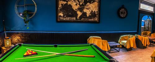 a green pool table with two bats on top of it at Hotel de l'Abbaye à Cluny in Cluny