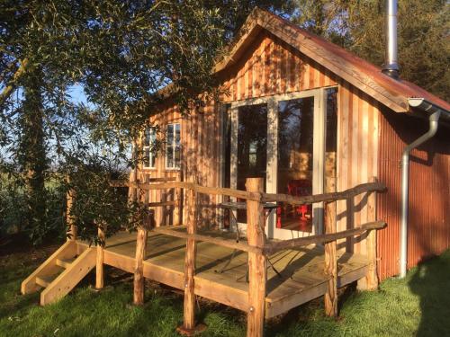 a tiny house with a porch and a deck at Retreat in Nature in Cardigan