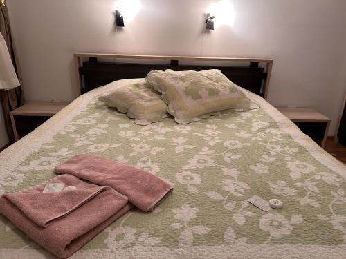 a bed with two towels and two pillows on it at Апартамент Планинско Гнездо - Mountain Nest in Stoykite