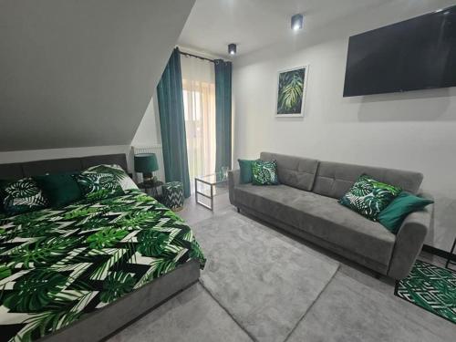 a living room with a bed and a couch at Sunrise Wola Mokrzeska Sala Bankietowa i Apartamenty in Wola Mokrzeska