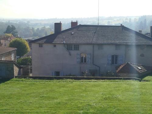 a white house with a green lawn in front of it at Aux Tilleuls de Renaison in Renaison