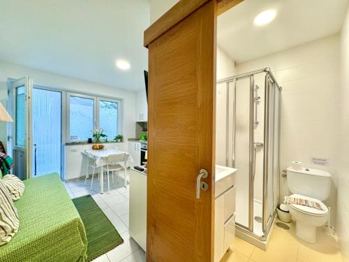 ein Bad mit einem WC und eine Küche mit einem Tisch in der Unterkunft Apartamento Peregrinos Por la Costa Camino Portugués As Casetas in Rosal