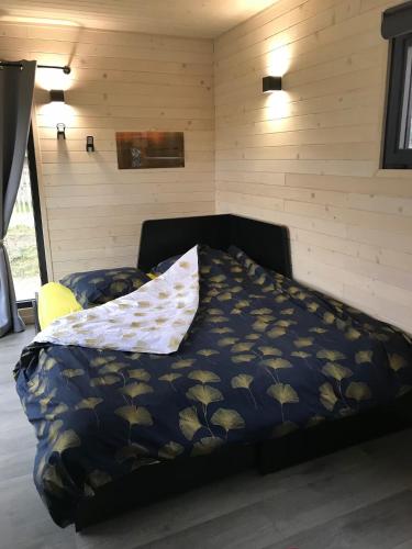 a bedroom with a bed with a pillow on it at La Roulotte - Tiny House 150m de la Plage in Portbail