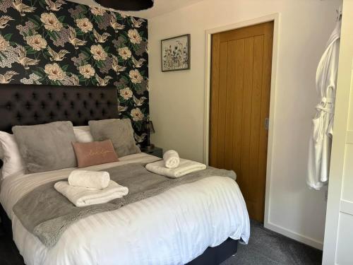 a bedroom with a bed with towels on it at Secret Gem 1 Bed Garden Flat Private Luxury Hot Tub in Bournemouth