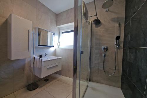 a bathroom with a shower and a sink at Villa Karizma - sea view, swimming pool, hot tub, Brijuni, Fazana, Peroj in Peroj