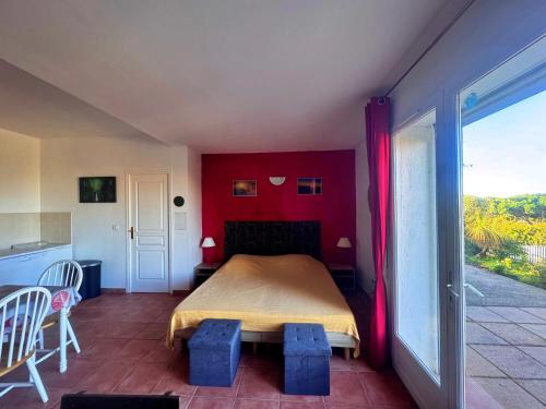 - une chambre dotée d'un lit avec un mur rouge dans l'établissement Agréable 2 pièces dans villa avec piscine, à Calvi
