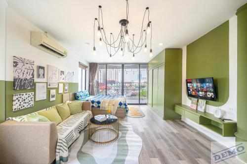a living room with a couch and a tv at Luxe Paradise Residence 273 Ton Duc Thang in Hanoi