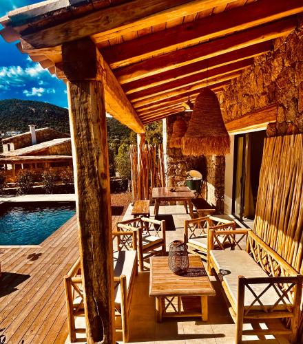 - une terrasse en bois avec des tables et des chaises à côté de la piscine dans l'établissement Bergerie U'caseddu, à Cirendinu