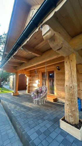 a porch of a wooden house with a bench at Ośrodek u Polaka-domek góralski in Radkowice