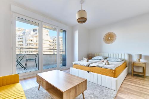 - une chambre avec un lit et une table basse dans l'établissement La Défense Apartment with Parking & Terrace, à Colombes