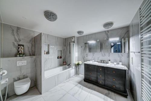 une salle de bain avec une baignoire, des toilettes et un lavabo dans l'établissement Villa KOSY, à Neuilly-Plaisance