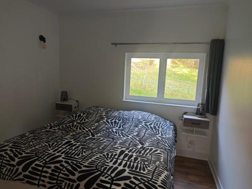 a bedroom with a bed and a window at Chalet insolite en Forêt in Ranspach