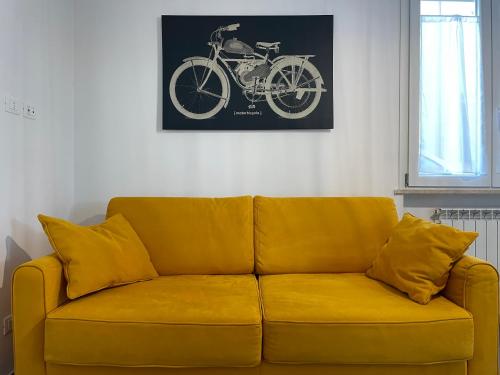 a yellow couch with pillows in a living room at Casa sul mare con accesso diretto in spiaggia I in Focene