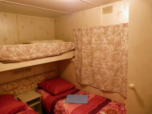 a small room with two bunk beds and a curtain at Chalet Alice in LʼHôpital-Saint-Blaise