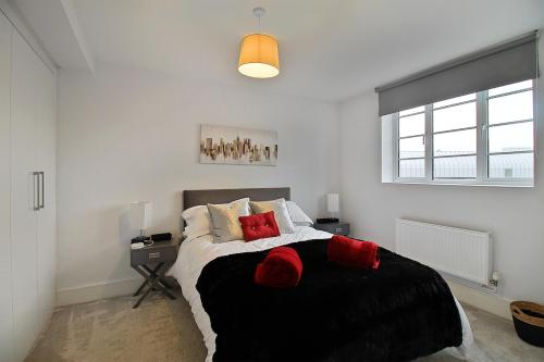 a bedroom with a large bed with red pillows at Flat in Central Slough - transport links in Slough