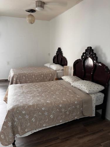 a bedroom with two beds and a ceiling at Hotel River Blue in Tlacotalpan