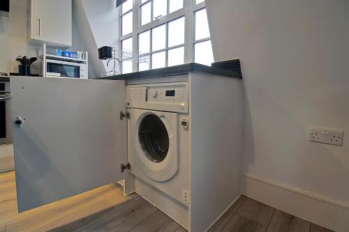 a kitchen with a washing machine in a room at Flat in Central Slough - transport links in Slough
