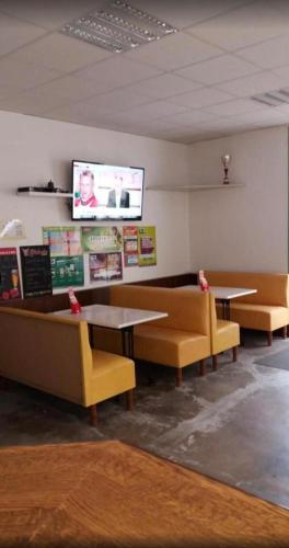 - une salle d'attente avec des canapés, des tables et une télévision à écran plat dans l'établissement Hôtel du siècle, à Cercy-la-Tour