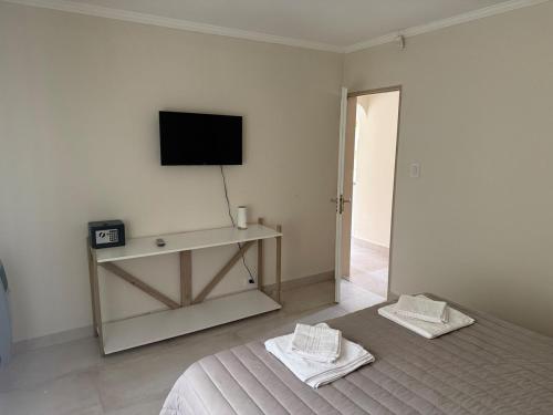 a bedroom with a bed and a tv on the wall at Cabaña Puente B 1 in El Calafate