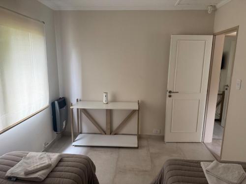 a white room with a table and a door at Cabaña Puente B 1 in El Calafate
