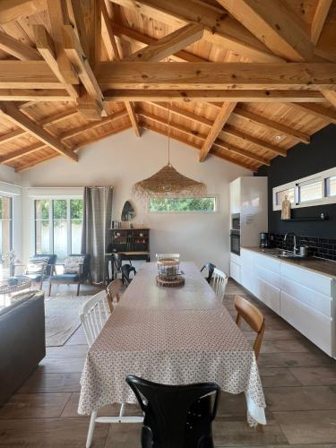 une cuisine et une salle à manger avec une table et des chaises dans l'établissement Maison de vacances 4 étoiles, Mimizan plage sud, à Mimizan-Plage