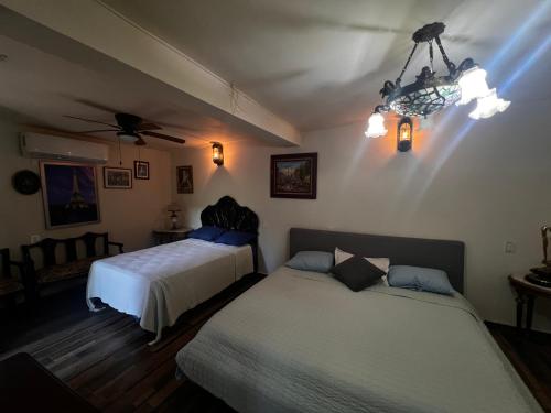a bedroom with two beds and a ceiling fan at Hotel River Blue in Tlacotalpan