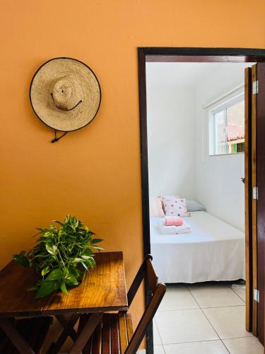 a hat on a wall next to a room with a bed at Microcasa Aconchego Paraty in Paraty